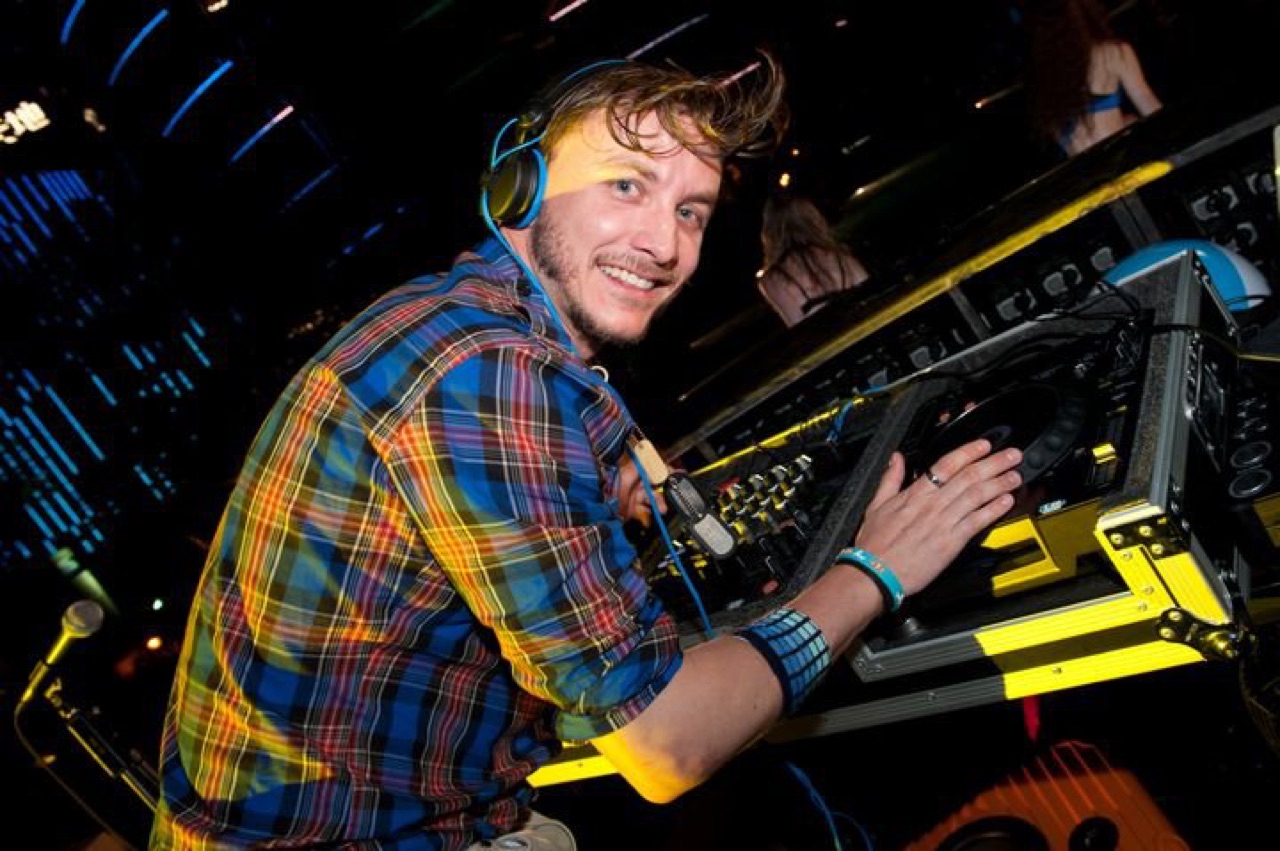 DJ Ryan Ash smiling at the decks in a Hong Kong club